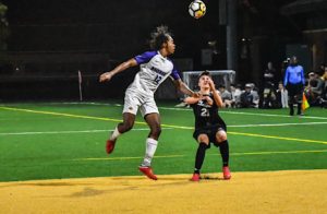 Darius Boamah (No. 12) wins a header in Emerson's 3-0 defeat to Clark University. Photo: Anissa Gardizy/Beacon Correspondent.