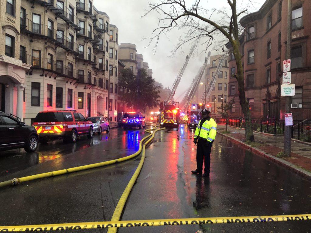 A Boston police officer stands watch as firefighters battle the seven alarm blaze at 104 Hemenway St. Oct. 27. Diana Bravo / Beacon Correspondent 