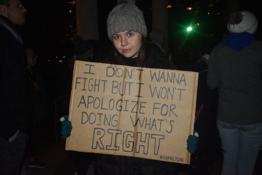 Freshman Laura Dinn held up a handmade sign at the Trump Doesn’t Represent Us Rally on Thursday night.  Photo by Abbey Finn / Beacon Correspondent  