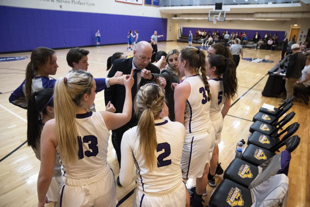 The Lions huddle before tip off in a game against Wheaton on Jan. 23. Photo by Daniel Peden / Beacon Staff