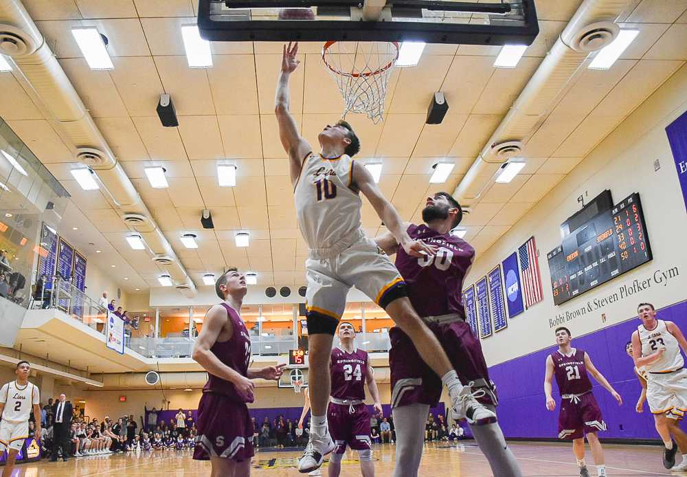 Freshman Zach Waterhouse finishes a reverse layup under the net for 2 of his 17 points against Springfield in the 2019 NEWMAC semifinals. 