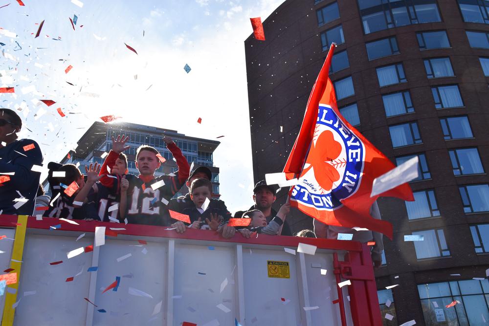 Kids wave to fans on the sidewalk during the parade. Photo by Anissa Gardizy / Beacon Staff