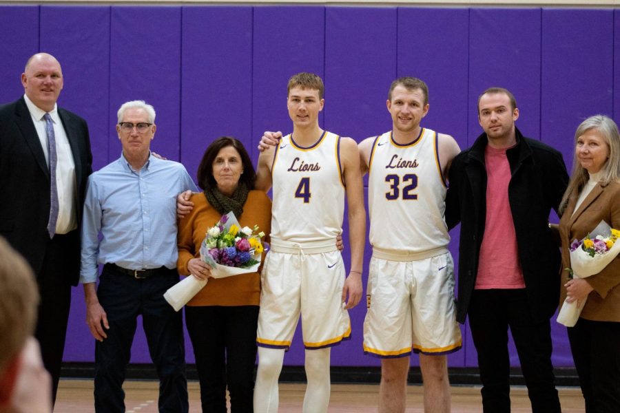Coach Bill Curley (left) poses with Jack OConnor (No. 4), Ben Holding (No. 32), and their family members during the pregame ceremony. Photo credit: Rachel Culver