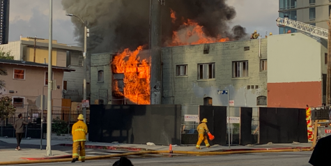 Firefighters attempt to extinguish a fire that broke out next to Emerson College's Los Angeles campus.