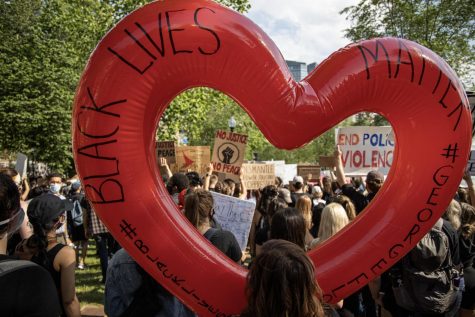 A woman holding an inflated red heart at Boston's third day of protests in response to the police killing of George Floyd.