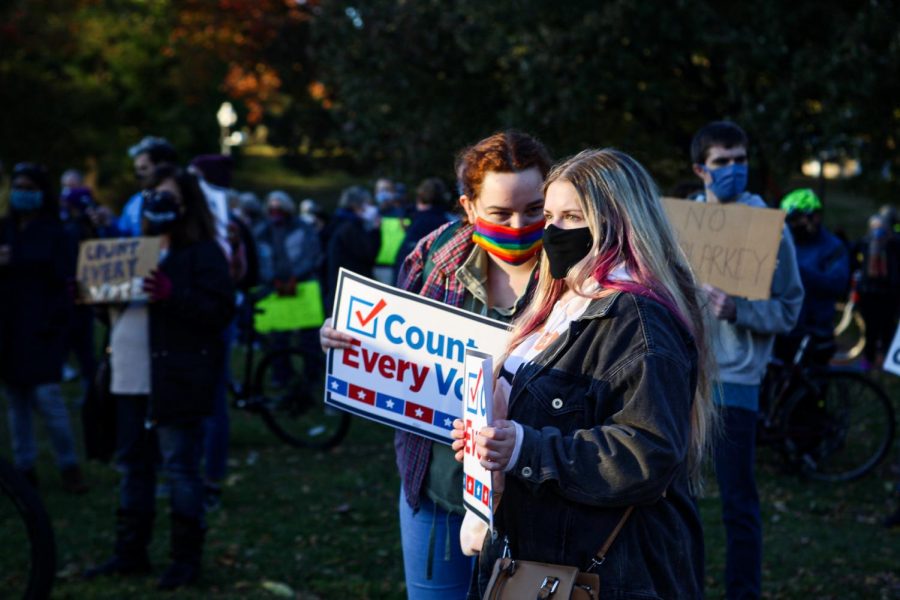 Two attendees listen to the Count Every Vote rally at Boston Common on Wednesday.