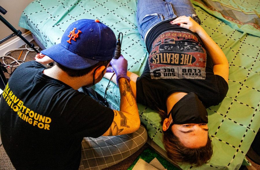 A client getting her tattoo on a mattress.