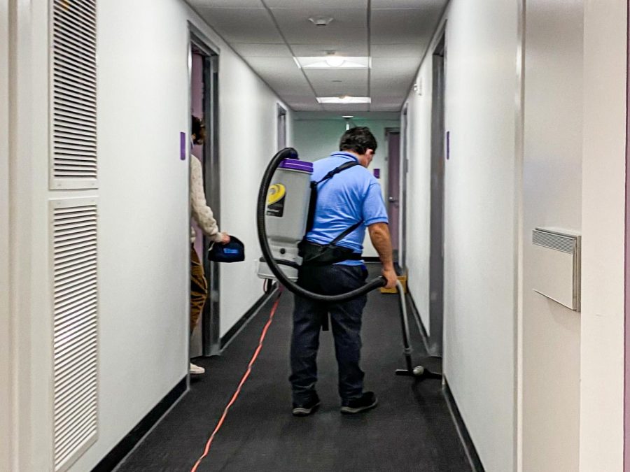 A janitor working in the dorm hallway.