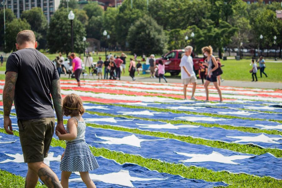 People visiting the giant flag display on the Common.