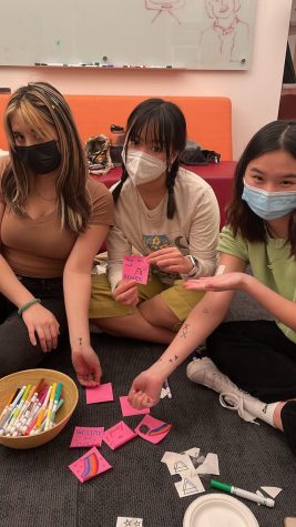 Three people pose for the camera at an ASIA (Asian Students in Alliance) meeting.