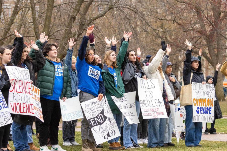 Protesters raising their hands to show the impact of gun violence on their lives.