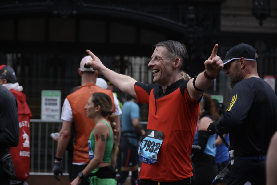 A runner puts his hands up near the Boylston Street finish line.