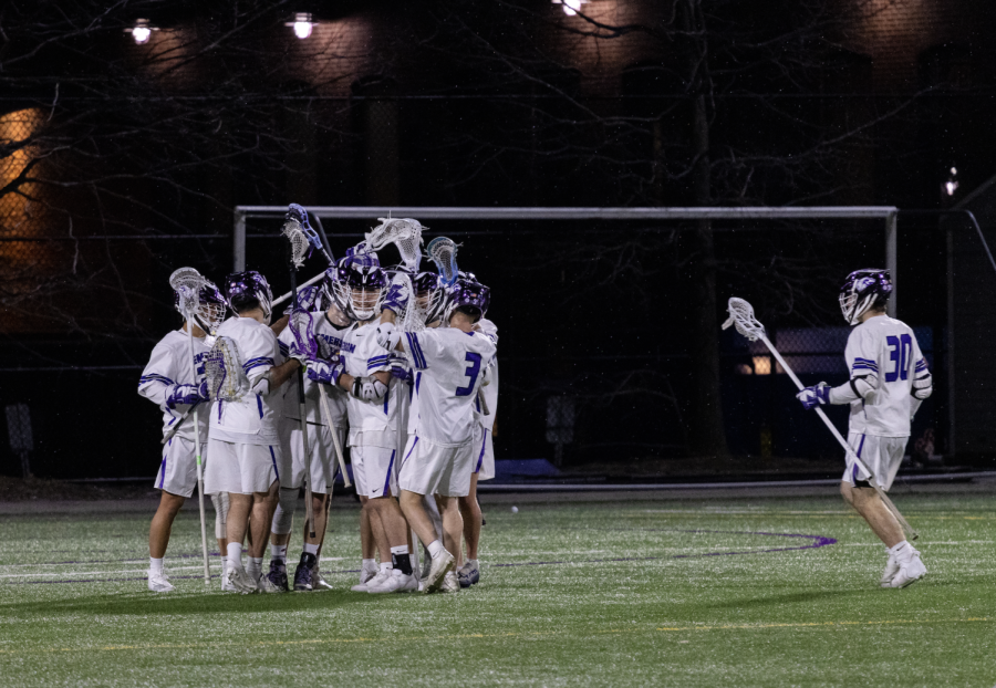 Men's lacrosse gathers on the field before a game. 