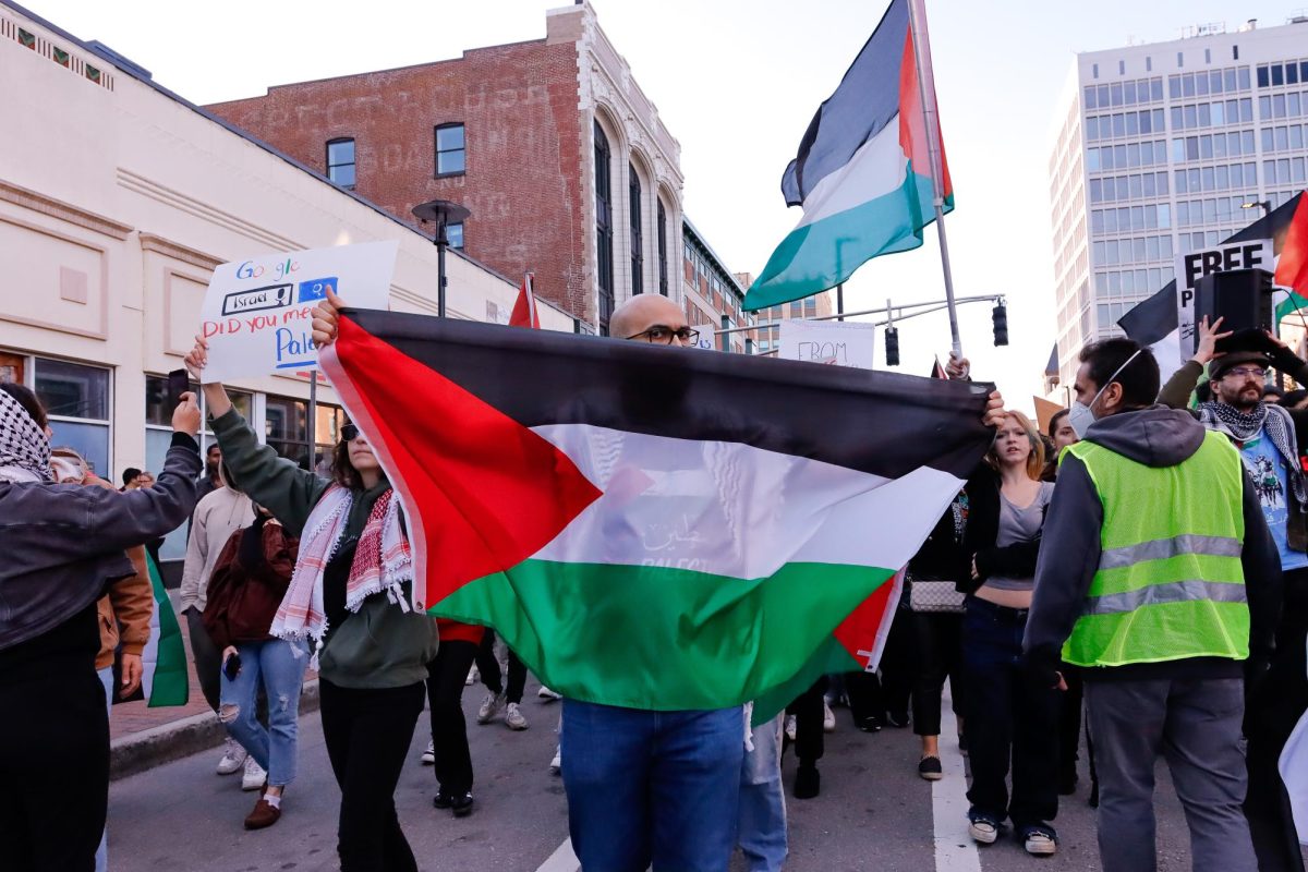 A+pro-Palestinian+protestor+holds+up+a+Palestinian+flag+during+a+march+in+Cambridge%2C+Massachusetts.