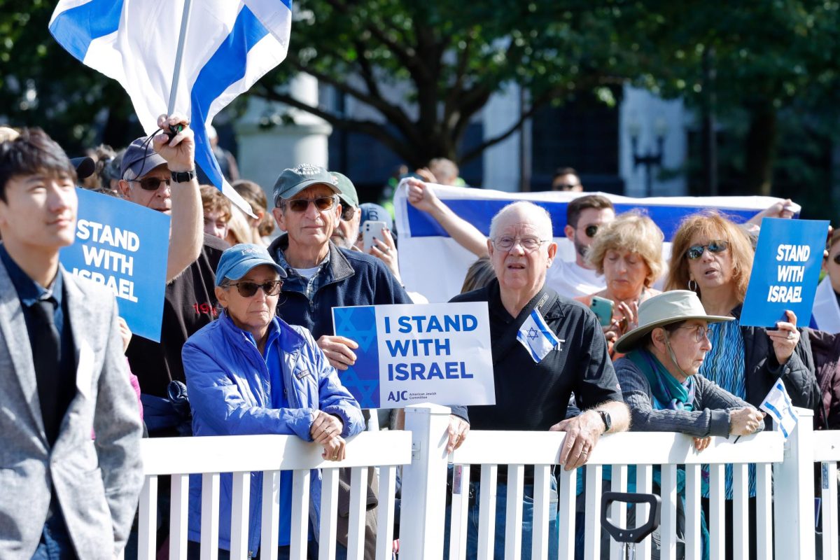 Attendees of the “Solidarity For Israel Under Fire” hold flags and signs supporting Israel.  (Arthur Mansavage/Beacon Staff)