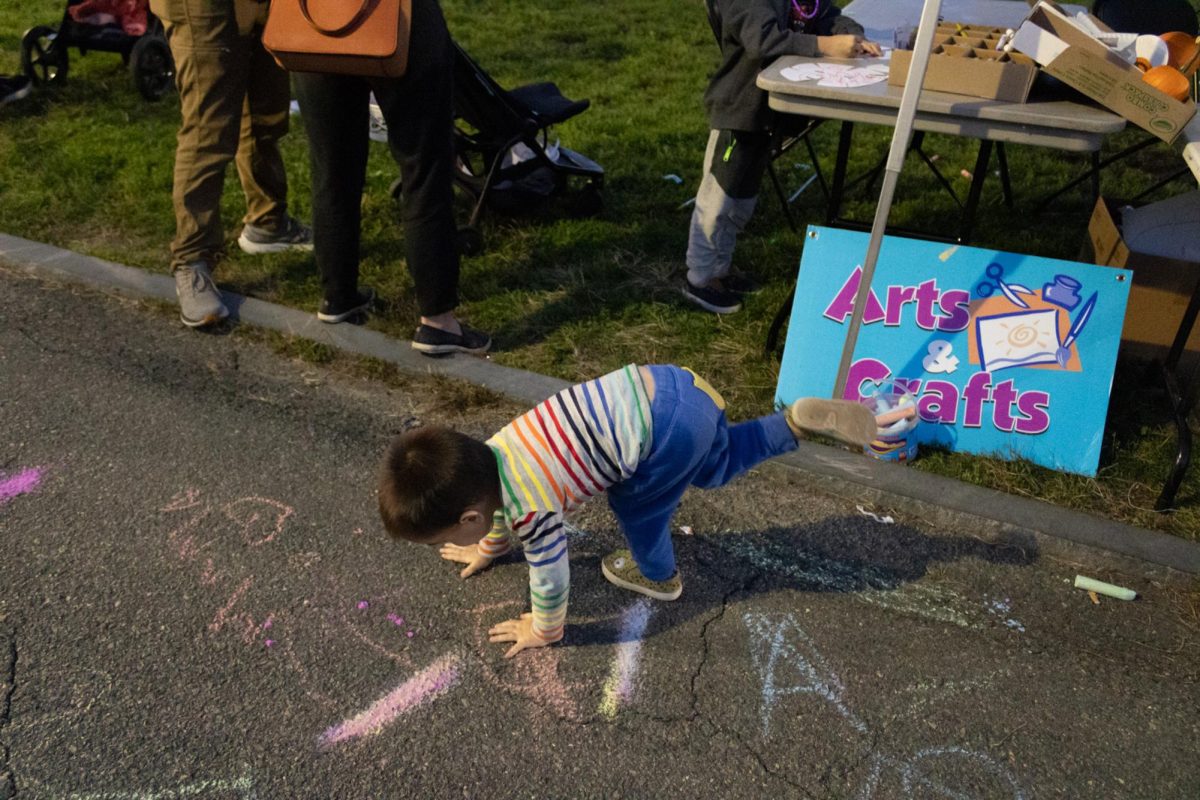 A child plays on the ground after spending some time at arts and crafts. (Sofia Waldron for The Beacon)