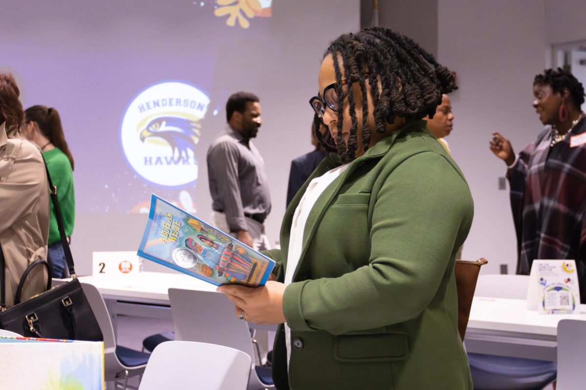 An attendee looks through one of the books donated to the Dr. William W. Henderson Inclusion School at the On the Same Page Bostons book donation campaign launch event on Tuesday, Oct. 17, 2023.