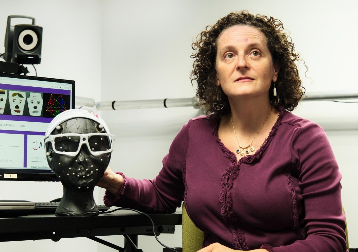 Communication Sciences and Disorders professor Ruth Grossman explains the purpose and operation of the SMI eye tracking glasses in a technology room.