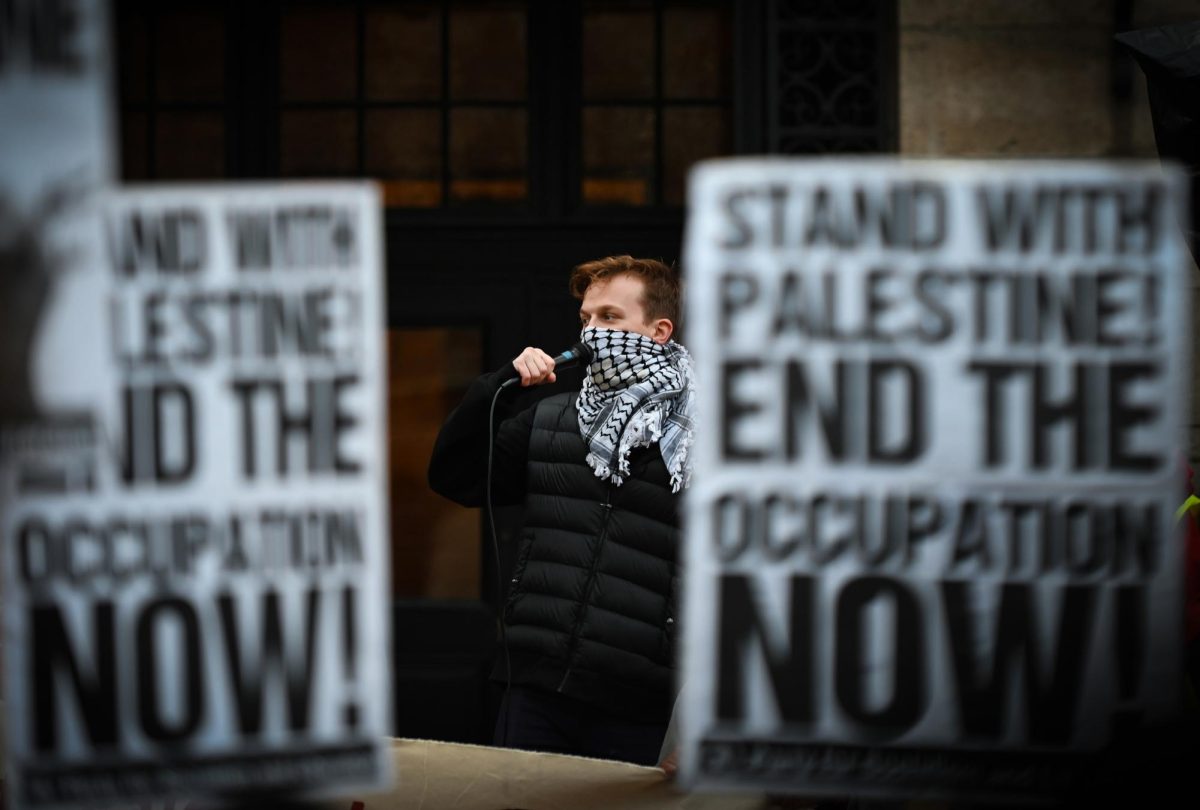 A man stands on the steps of the Boston Public Library and leads the crowd in a chant at the beginning of the All Out for Palestine rally in Copley Square on Monday, Oct. 16, 2023. (Ashlyn Wang/Beacon Staff)