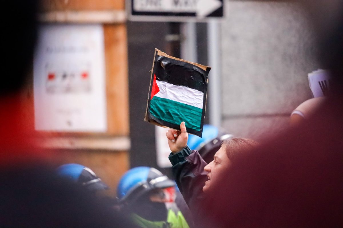 A protester holds up a piece of cardboard that resembles the Palestinian flag during the rally on Thursday, Nov. 9, 2023. (Arthur Mansavage/Beacon Staff)