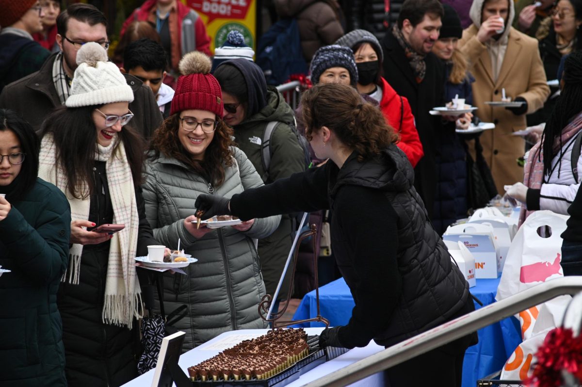 People sample free chocolate provided by local businesses at the 16th annual Harvard Square Taste of Chocolate fair, some waiting over an hour in the cold to sample a few morsels of chocolate in Cambridge, Mass., on Saturday, Jan. 27, 2024. (Amin S. Lotfi/Beacon Staff)
