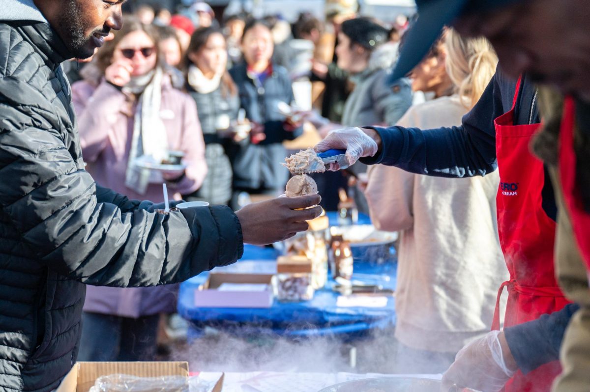 A vendor gives chocolate ice cream to a customer at the Harvard Square Taste of Chocolate Festival in Cambridge, Mass., on Saturday, Jan. 27, 2024. (Frank Chen for the Beacon)
