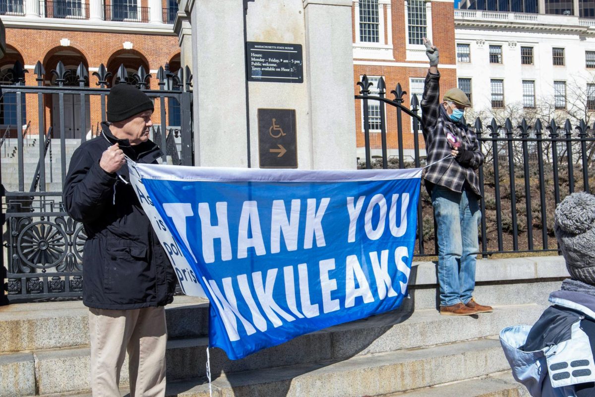 Protestors hold up banners to show support for Julian Assange at the Massachusetts State House on Thursday, Feb. 22, 2024. (Rian Nelson/Beacon Correspondent)