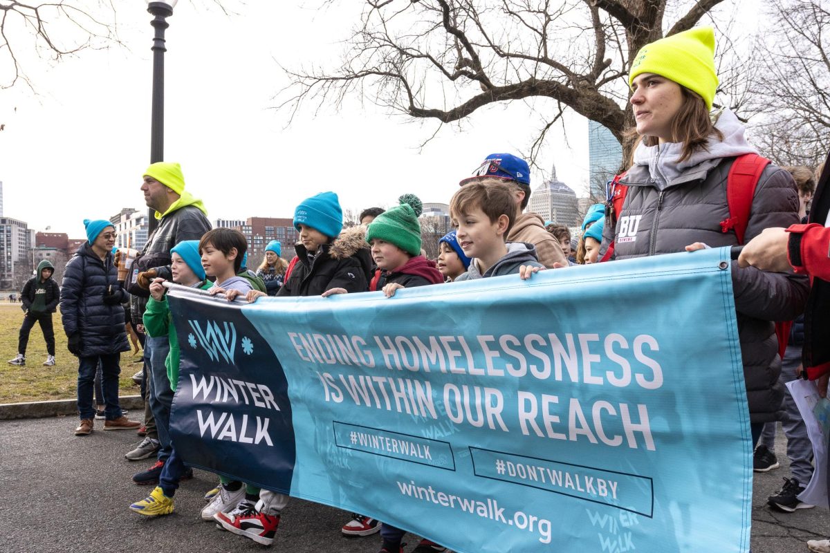 Participants carry a banner that reads Ending homelessness is within our reach as they lead the crowd of around 4,000 people on the two-mile walk around the Boston Common and the Public Garden on Sunday, Feb. 11, 2024. (Arthur Mansavage/Beacon Staff)