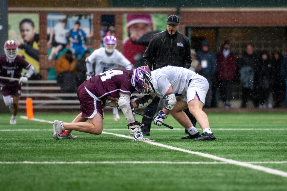 An Emerson College mens lacrosse team player scrambles for the ball against a Springfield College player on kickoffs during the game against Springfield College on Saturday, March 25, 2024. The Emerson Lions triumph over Springfield with a final score of 12-10. (Feixu Chen/ Beacon Staff)