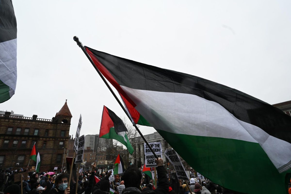 Protesters wave Palestinian flags outside of Cambridge City Hall during the rally on Saturday, March 2, 2024.  (Margaux Jubin/Beacon Staff)