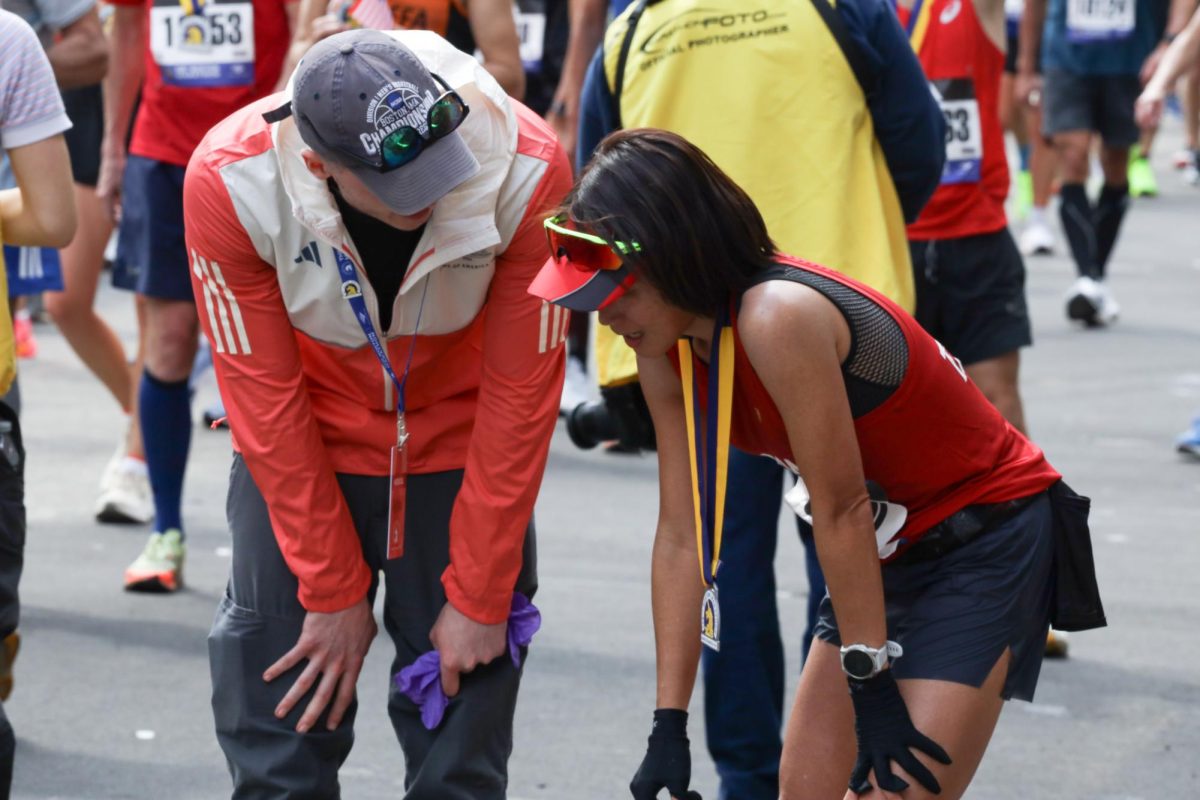 A member of the medical support staff checks on a runner at the finish line of the 128th Boston Marathon on Monday, April 15, 2024. (Madla Walsh/Beacon Staff)