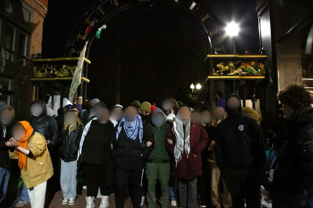 Protesters lock arms in a chain moments before Boston Police break into the front of the encampment on Thursday, April 25, 2024. (Julian Grady for the Beacon) 