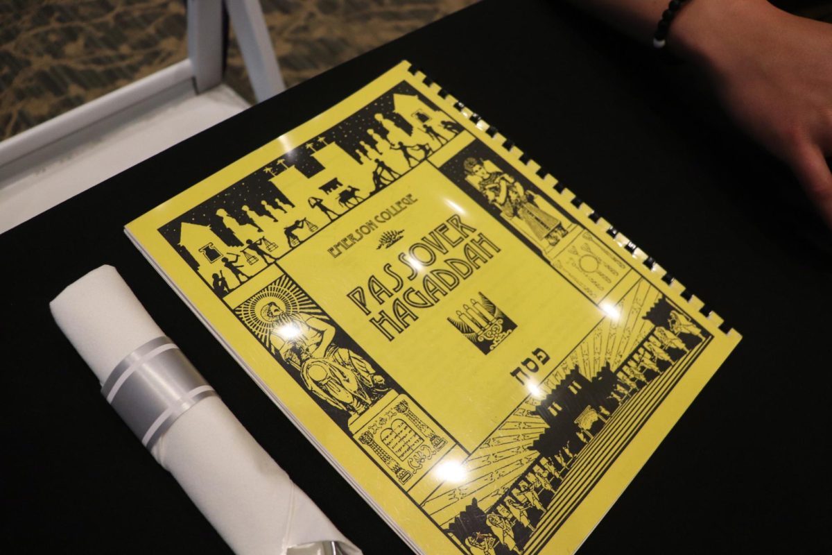 Place settings for the Seder include bound copies of the Passover Haggadah, the traditional Jewish Seder text from which prayers, stories, and songs are read. (Bryan Hecht/Beacon Staff)