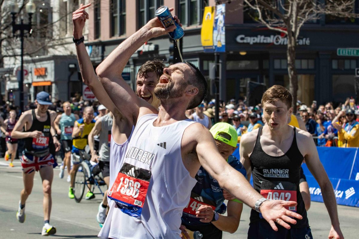 A runner pours a beer over his head right before the finish line to celebrate during the 128th Boston Marathon on Monday, April 15, 2024. (Rian Nelson/Beacon Staff)