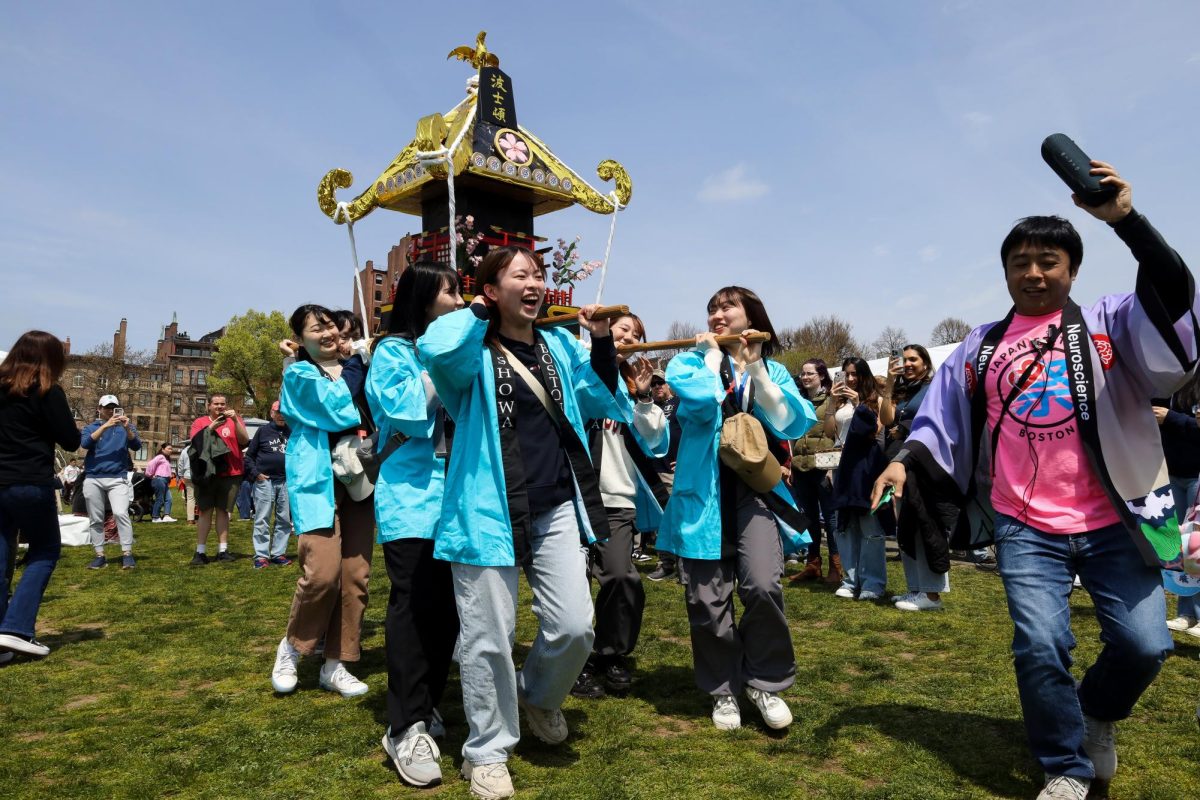 A group of women dances through the Japan Festival grounds carrying a mikoshi, a portable shrine, on their shoulders on Boston Common on Sunday, April 28, 2024. (Madla Walsh/Beacon Staff)