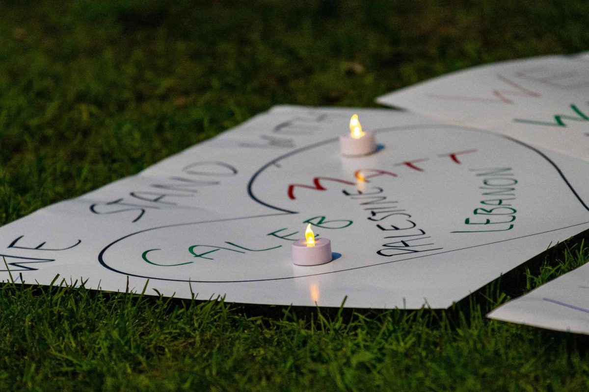 A poster saying "We Stand with Caleb, Matt, Palestine, Lebanon" lies on the ground before a makeshift memorial in the Boston Garden at a vigil held by the Muslim Justice League on September 25, 2024. The vigil honored the lives of Matt Nelson, who died after self-immolated in front of Boston's Israeli consulate, and Caleb Cannon, who is in serious condition after being shot during a pro-Palestine protest in Newton. (Rian Nelson / Beacon Staff)