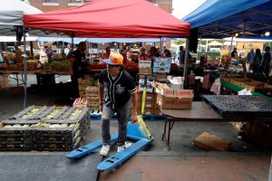 A vendor carries fresh boxes of produce to his stand at the Haymarket. (Madla Walsh/ Beacon Staff)