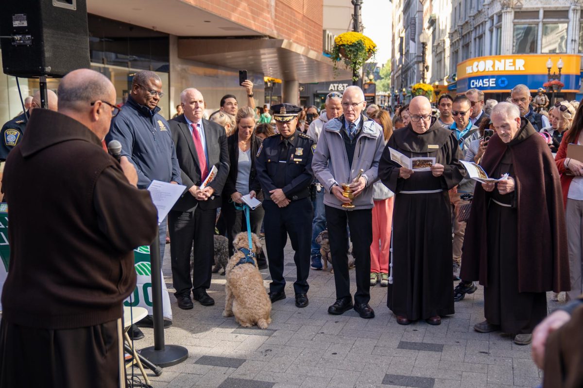 The priest at St. Anthony Shrine, Boston police officers and citizens prayed together at the blessing of the animals held at Summer Street Plaza on Sunday, October 6, 2024. (Feixu Chen/ Beacon Correspondent)