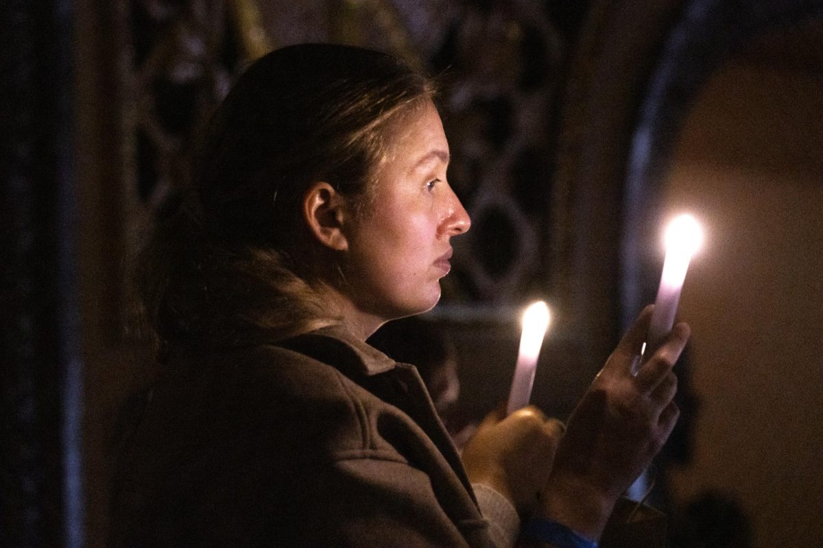 An attendee holding a battery candle during a prayer portion of the remembrance event at The Wang Theatre on Monday October 7, 2024. (Arthur Mansavage/ Beacon Staff)