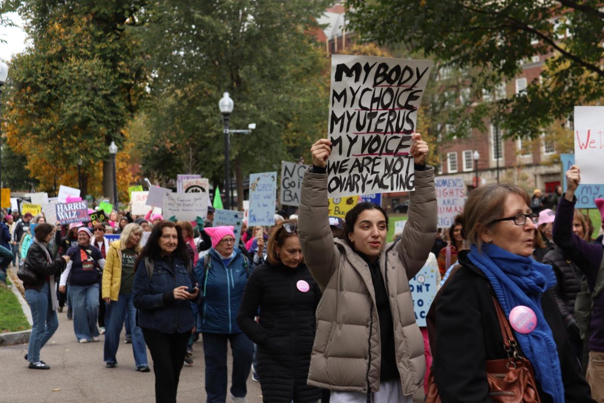 A pro-choice protester marches with a sign during a women's march for Kamala Harris in Boston ahead of the 2024 presidential election on Nov. 2, 2024 (Hannah Brueske/ Beacon Staff).