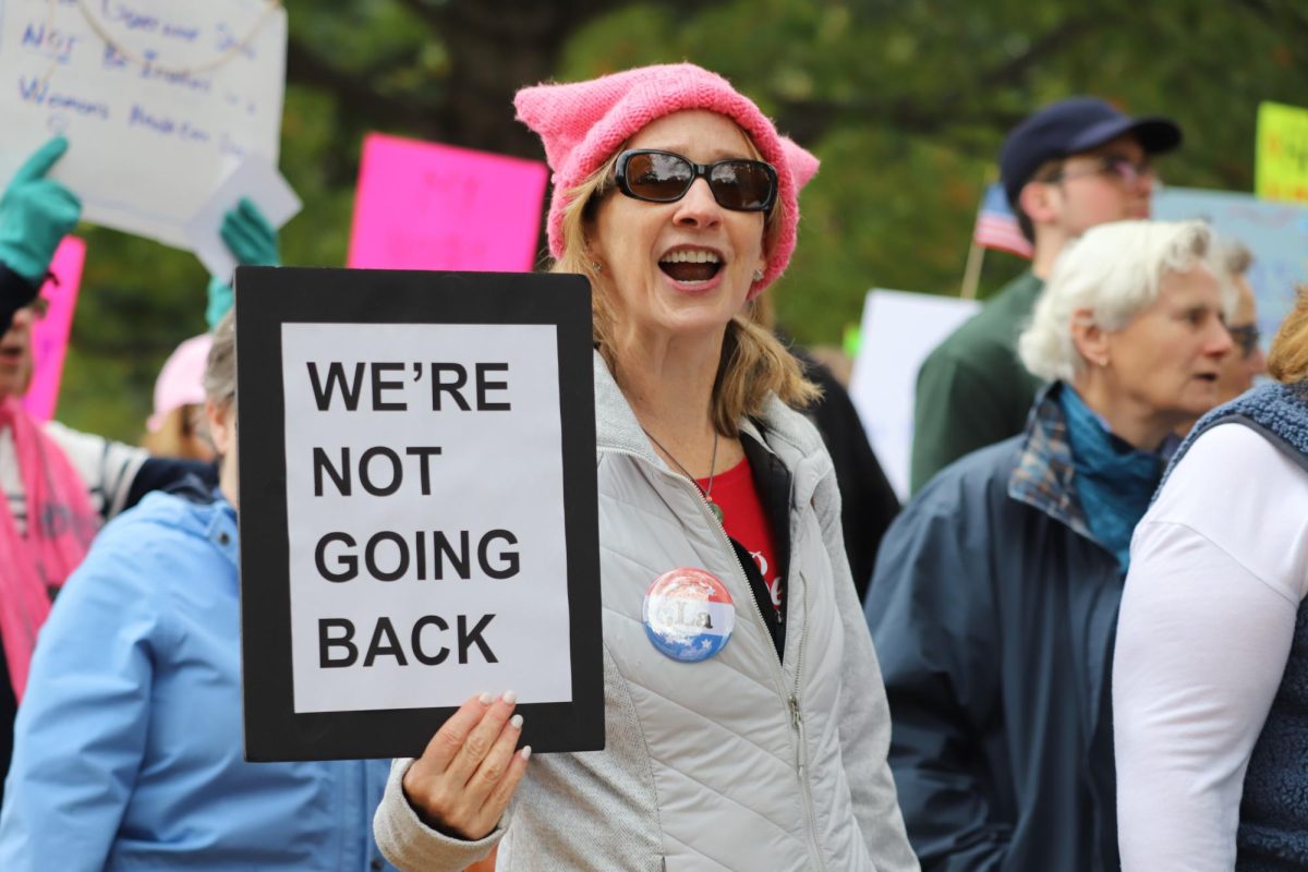 A march attendee hold up a sign that reads "we're not going back". (Sophia Schiappa/ Beacon Correspondent)