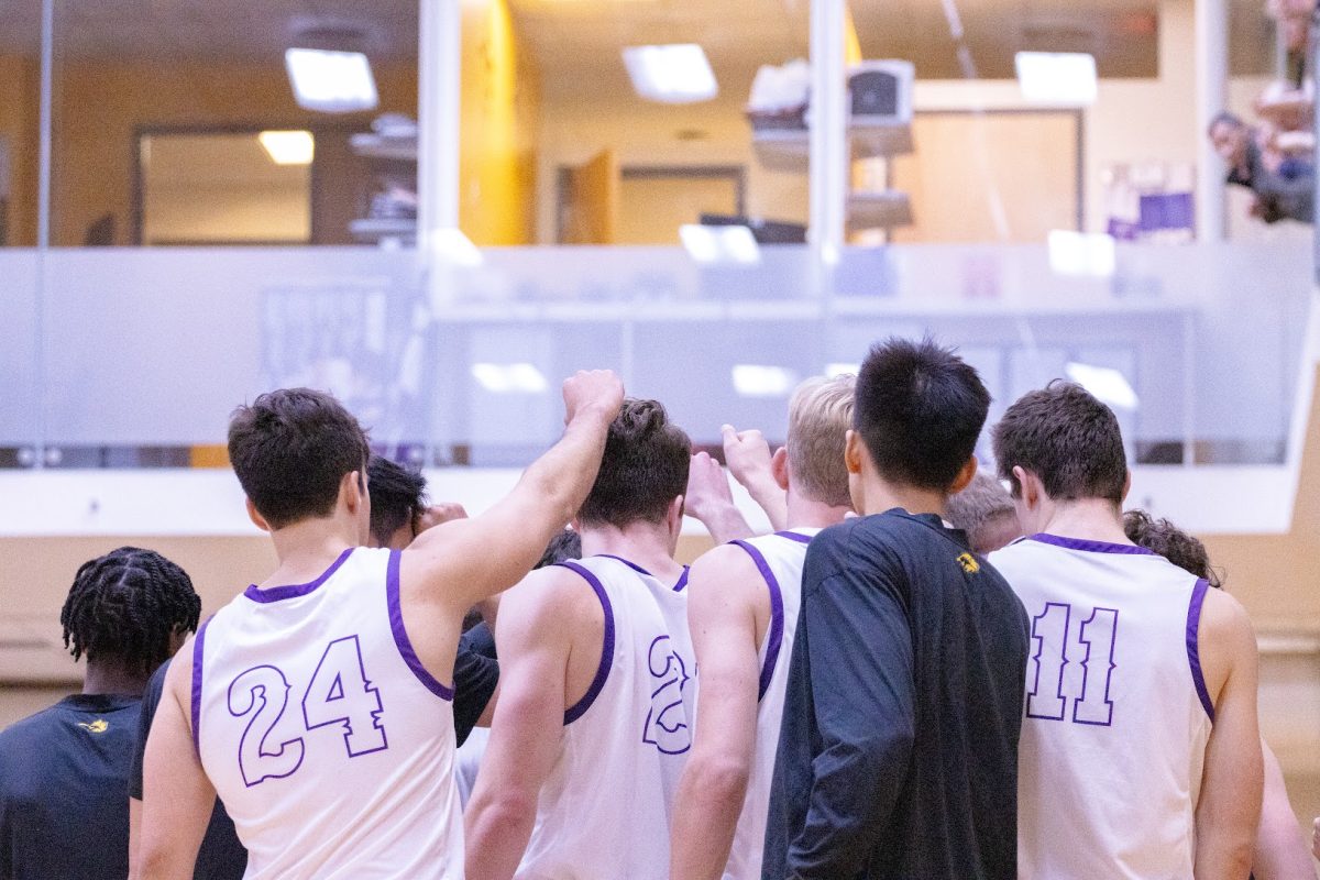 The Emerson men's basketball team in a huddle against Salem State (Arthur Mansavage/ Beacon Staff, File)