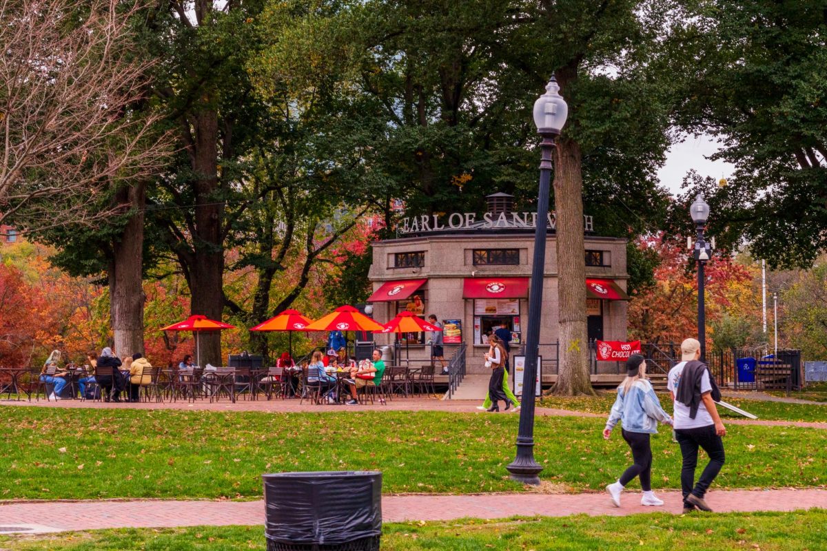 People sitting at tables and chair outside of the Boston Common Concession Stand on November 11, 2022. (Arthur Mansavage/ Beacon Staff, File)