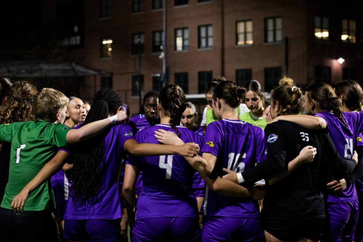 The Emerson women's soccer team in a huddle against WPI in the 2024 NEWMAC semifinals (Courtesy of Naia Driscoll).