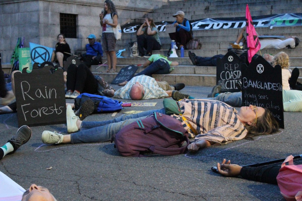 People play dead on the steps of the Massachusetts State House to represent climate change casualties during a rally on Friday, Sept. 27, 2024. (Shannon Clark for The Berkeley Beacon)