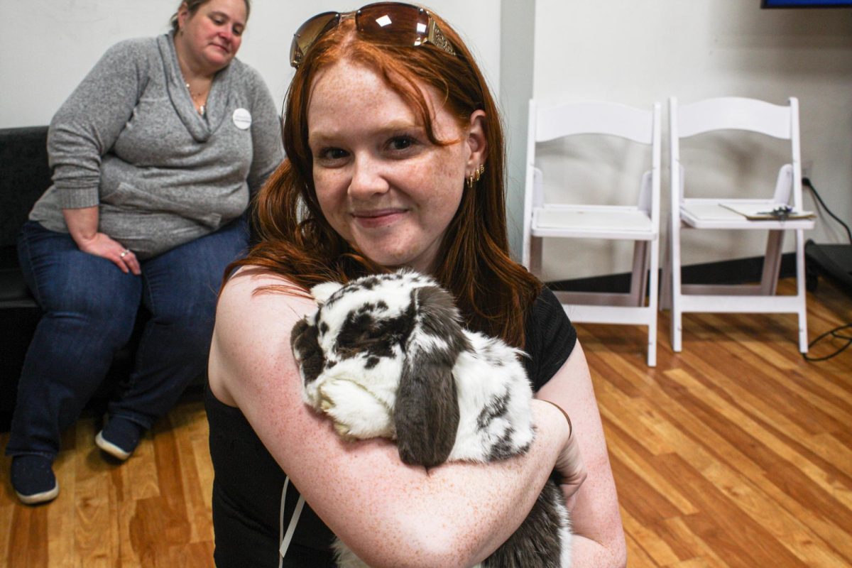 A student holding a bunny poses for a photo during the Relaxapalooza event in the  Iwasaki Library on Friday, Dec. 6, 2024. (Abigail Hoyt/ Beacon Correspondent)