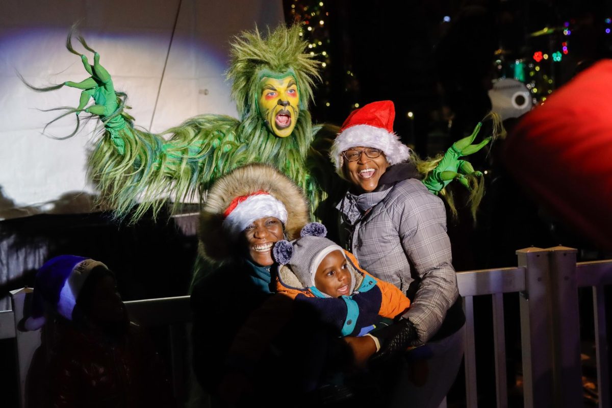 A family poses with The Grinch during the tree lighting event in the Boston Common on Thursday, Dec. 5, 2024. (Arthur Mansavage/ Beacon Staff)