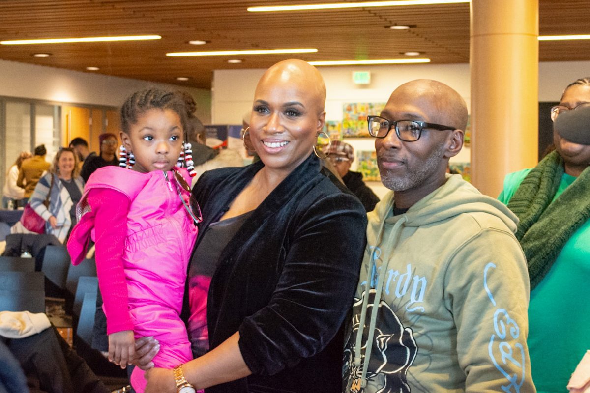 Rep. Ayanna Pressley (D-MA) spoke with constituents and held a young girl while talking to her relative at the "Day of Beloved Community" event she hosted Monday, Martin Luther King Jr. Day and skipping President Donald Trump's inauguration Jan. 20. (Ari Mei-Dan/Beacon Staff)