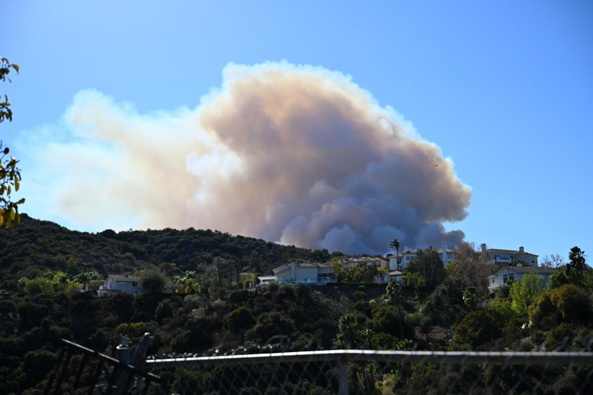 A cloud of smoke from the Palisades fire billows over a hill near the neighborhood of Encino on Saturday, Jan. 11, 2025. (Riley Goldman/ Beacon Staff)