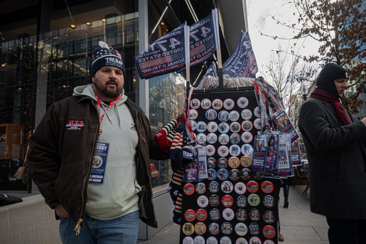 A vendor pulls his cart of Trump merchandise towards the crowds waiting outside the Capital One Arena for President  Trump’s rally. Monday, Jan. 20, 2024. (Nick Peace/Beacon Staff)